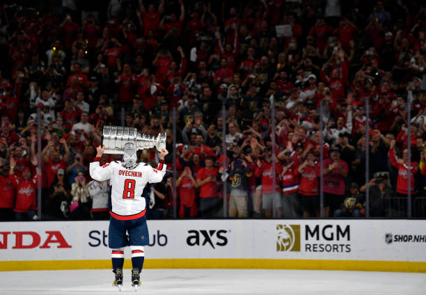 an ice hockey player holding a trophy